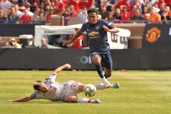 Liverpool Midfielder Adam Lallana (20) attempts to knock away the ball as Manchester United Defender Demetri Mitchell (35) jumps over during the IC...