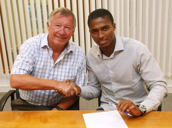 Luis Antonio Valencia (R) shakes hands with Manchester United's manager Sir Alex Ferguson after signing for Manchester United at Carrington Trainin...