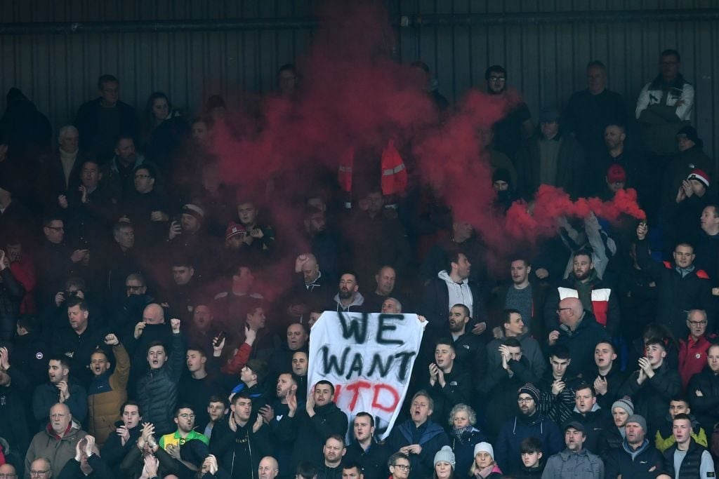 Manchester United fans hold up a banner stating "we want utd back" in the crowd during the English FA Cup fourth round football match between Tranmere Rovers and Manchester United at Prenton Park in Birkenhead, north west England, on January 26, 2020. (Photo by Paul ELLIS / AFP) / RESTRICTED TO EDITORIAL USE. No use with unauthorized audio, video, data, fixture lists, club/league logos or 'live' services. Online in-match use limited to 120 images. An additional 40 images may be used in extra time. No video emulation. Social media in-match use limited to 120 images. An additional 40 images may be used in extra time. No use in betting publications, games or single club/league/player publications. Glazer protest United. Ed Woodward. 