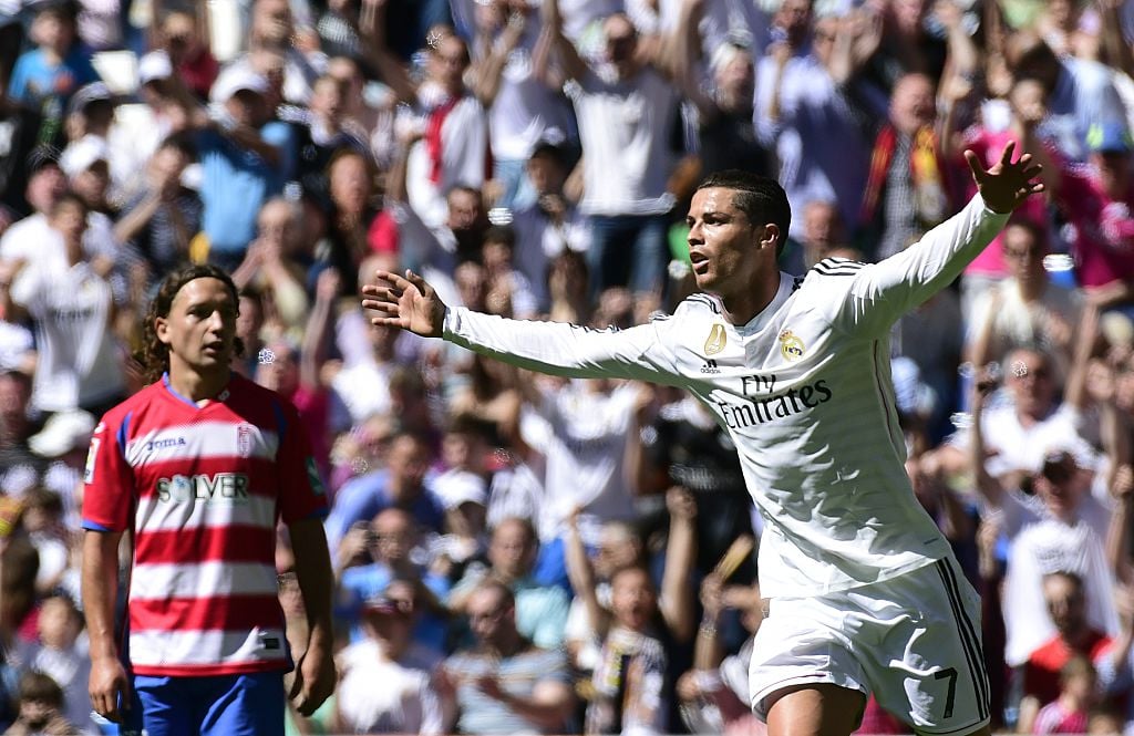 Real Madrid's Portuguese forward Cristiano Ronaldo (R) celebrates a goal past Granada's Chilean midfielder Manuel Rolando Iturra (L) during the Spa...