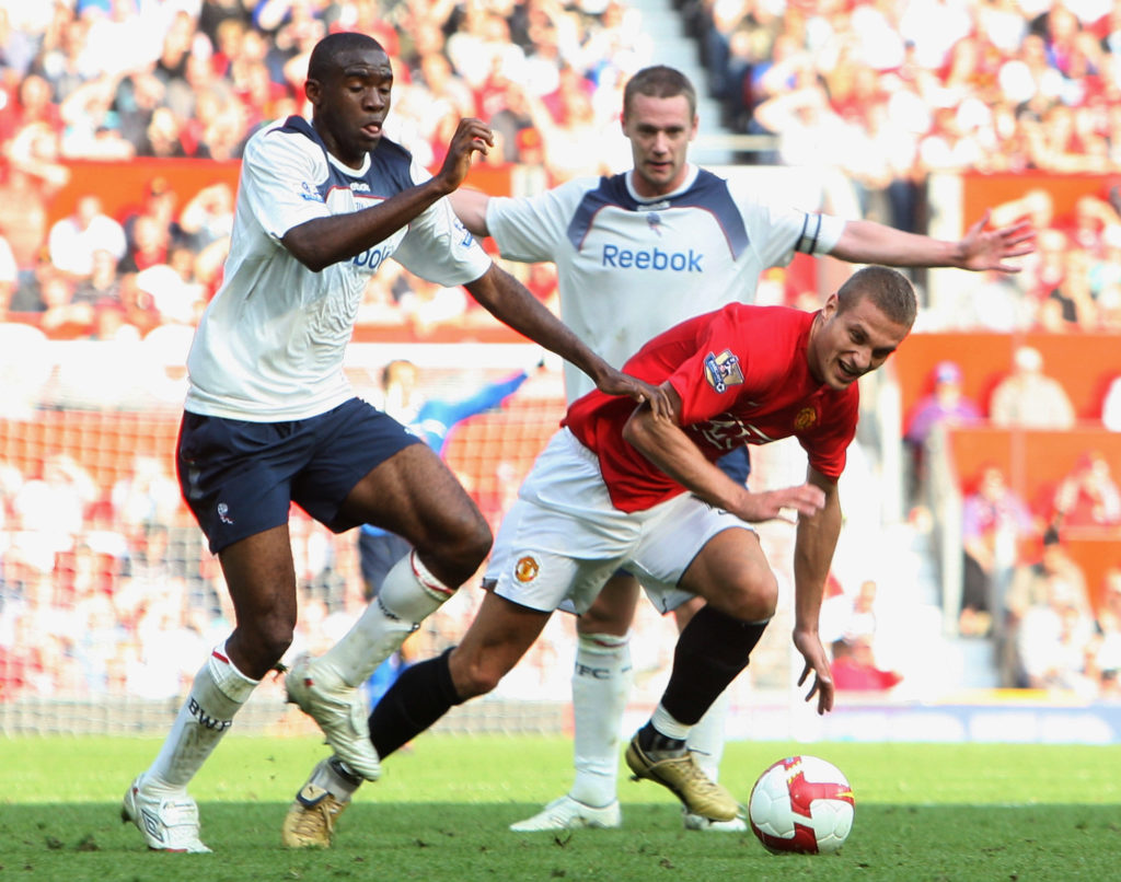 Nemanja Vidic of Manchester United clashes with Fabrice Muamba of Bolton Wanderers during the FA Premier League match between Manchester United and...