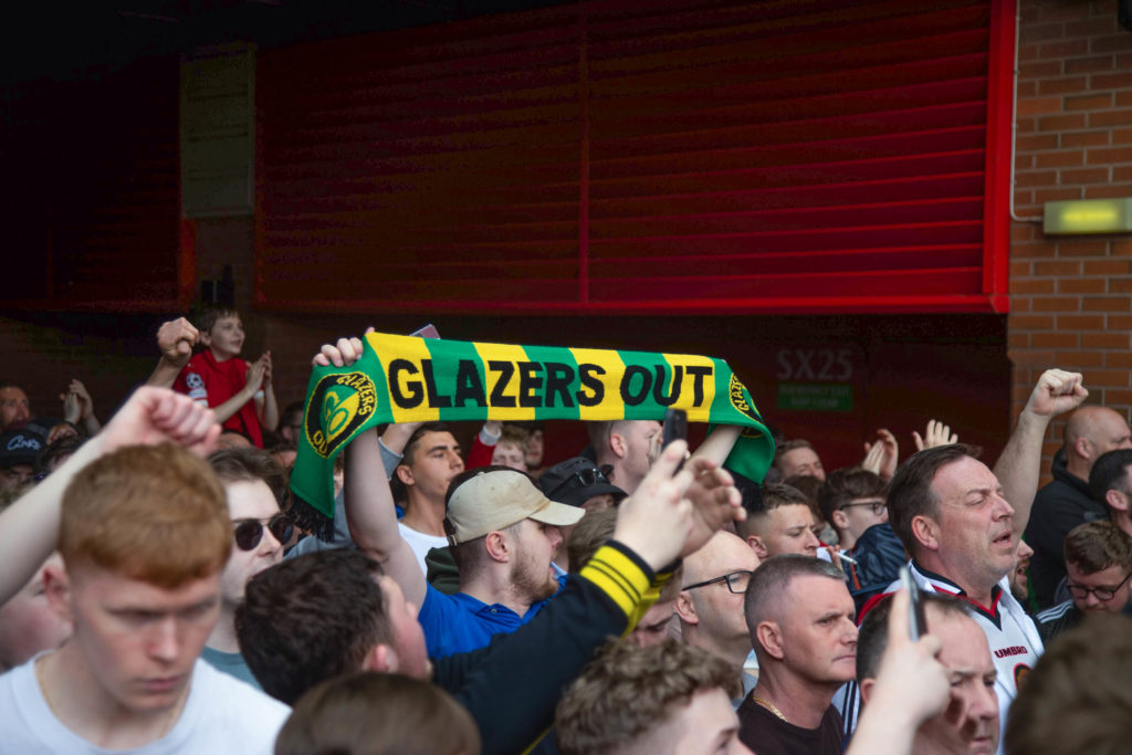 A fan holds a Glazers out banner during the demonstration.