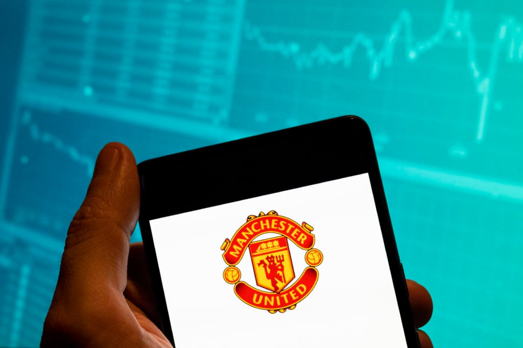 In this photo illustration, the logo of professional Premier League football club Manchester United (MU) is seen on a smartphone with an eco symbol.