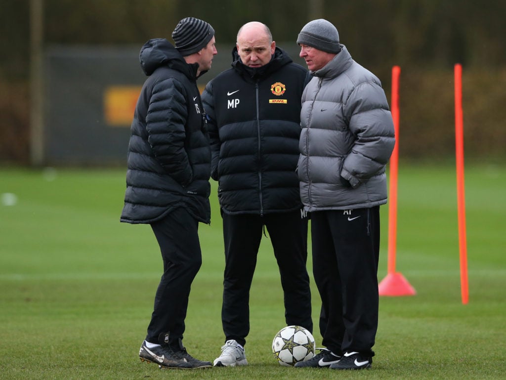Sir Alex Ferguson the manager of Manchester United (r) talks with Assistant Manager Mike Phelan (c) and Fitness Coach Tony Strudwick (l) during a t...