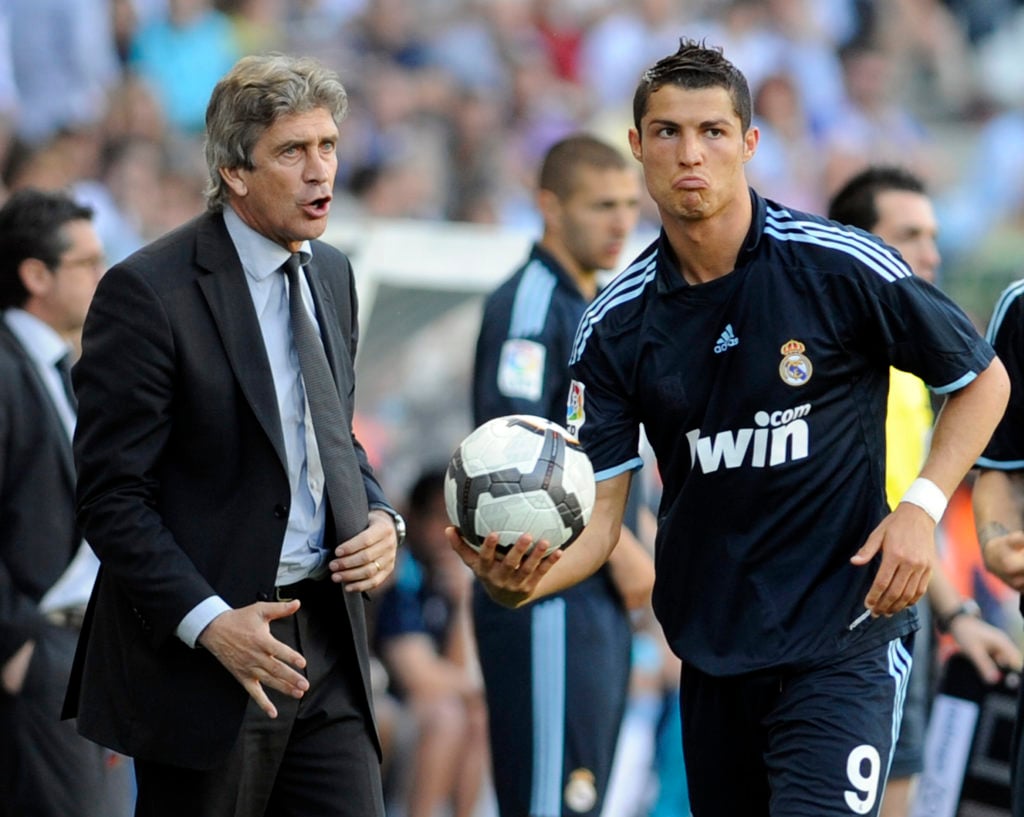 Real Madrid's Portuguese forward Cristiano Ronaldo (R) holds a ball as he stands next to Real Madrid's coach Manuel Pellegrini (L) during a footbal...