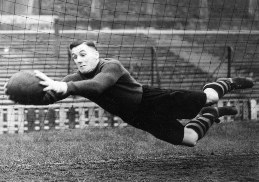 Manchester United goalkeeper Jack Crompton makes a flying save during a training session. Circa 1948.