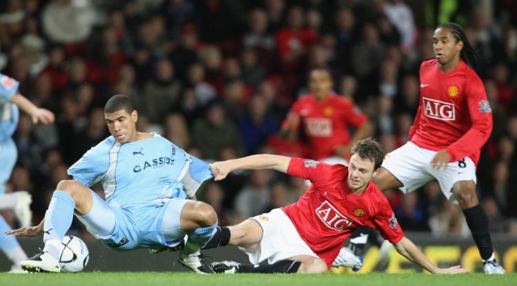 Jonny Evans of Manchester United clashes with Leon Best of Coventry City during the Carling Cup match between Manchester United and Coventry City a...