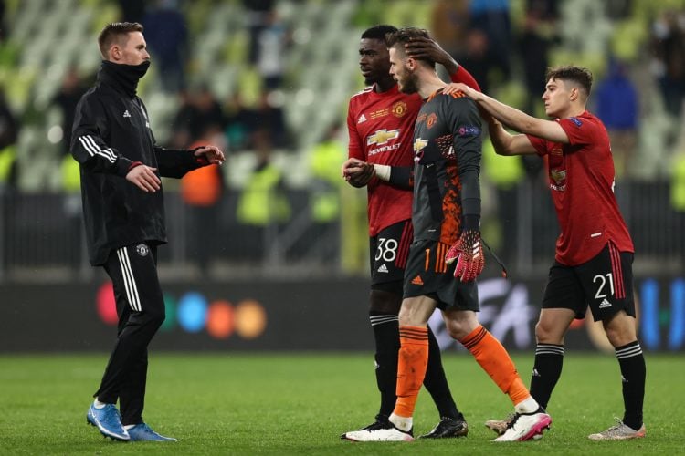 Manchester United's Welsh midfielder Daniel James (R) and Manchester United's Congo-born English defender Axel Tuanzebe (C) console Manchester Unit...