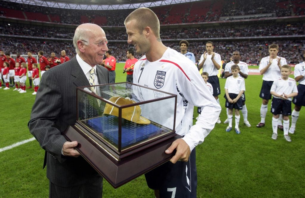 David Beckham of England receives his 100th cap from Sir Bobby Charlton before the International Friendly match between England and USA at Wembley ...