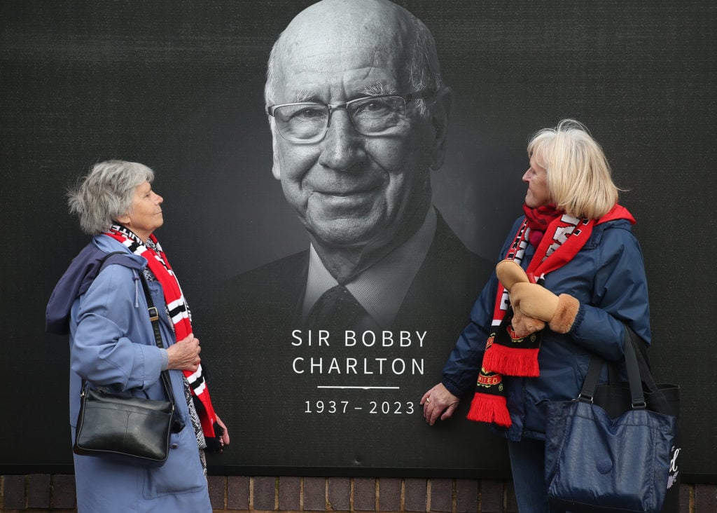 Mourners gather to pay their respects at Old Trafford as Sir Bobby Charlton's hearse passes the stadium on the way to his funeral on November 13, 2...