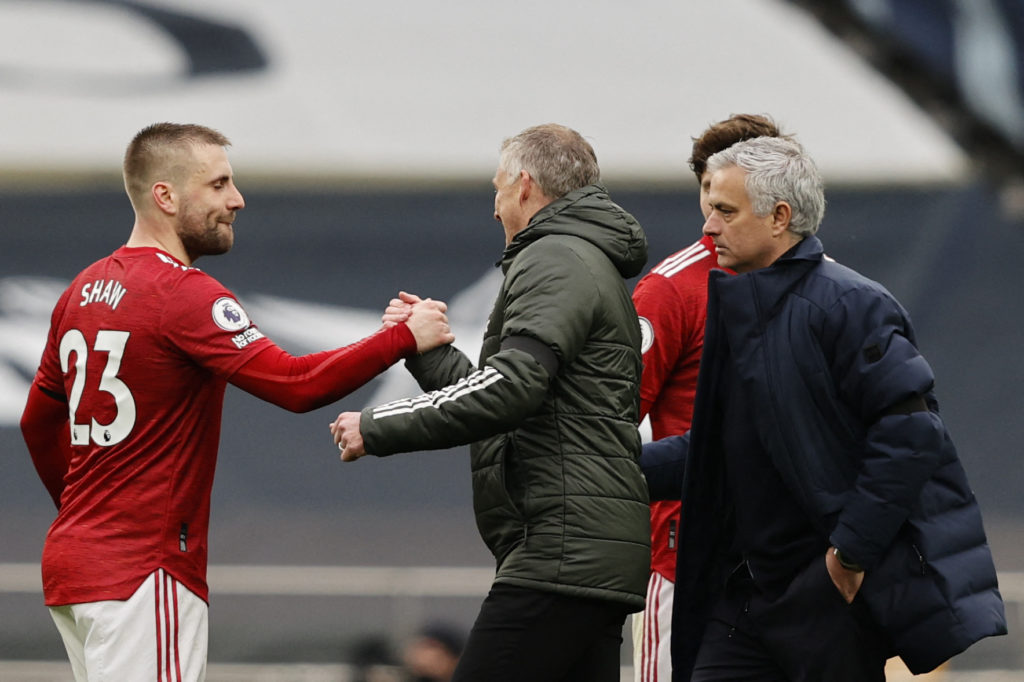Luke Shaw and Ole Gunnar Solskjaer sharing a moment in front of Jose Mourinho