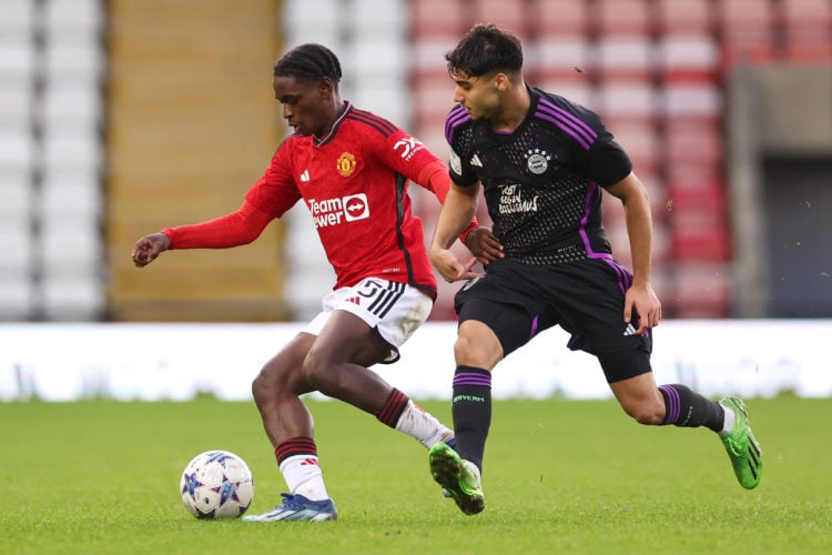 Habeeb Ogunneye of Manchester United is challenged by Emirhan Demircan of Bayern Munich during the UEFA Youth League - Group A match between Manche...