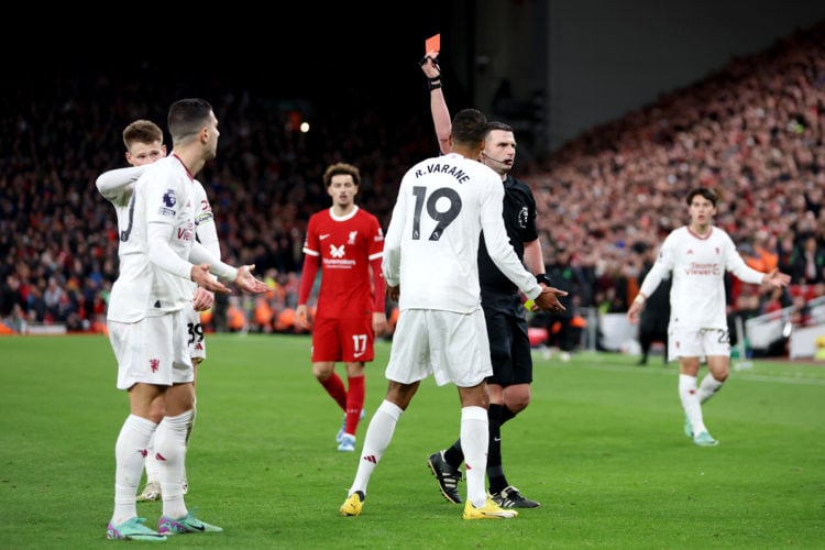 Referee Michael Oliver shows a red card to Diogo Dalot of Manchester United after dissent during the Premier League match between Liverpool FC and ...