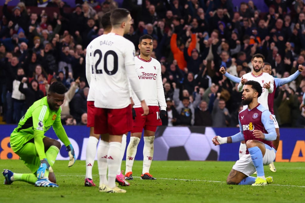 Douglas Luiz of Aston Villa shimmies as he celebrates his goal in front of the Manchester United players