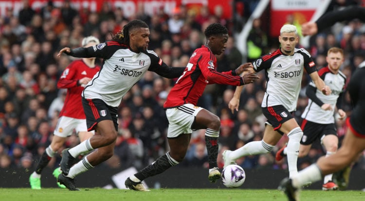 Kobbie Mainoo of Manchester United in action with Alex Iwobi of Fulham during the Premier League match between Manchester United and Fulham FC at O...