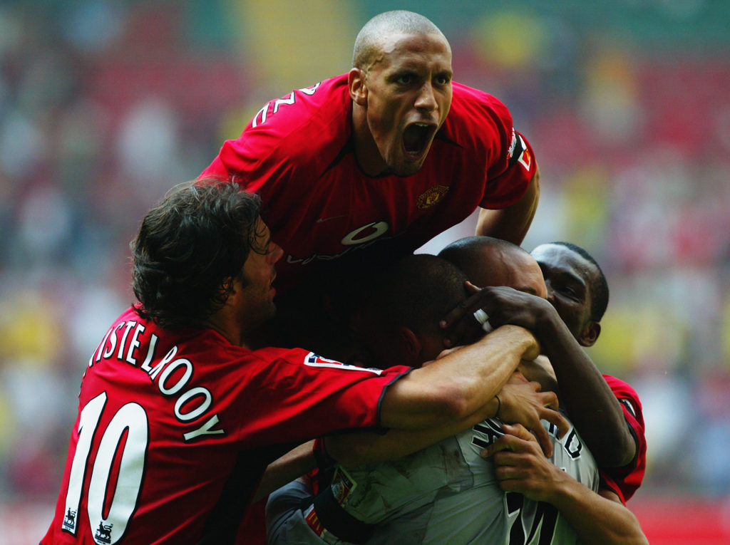 Rio Ferdinand of Manchester United jumps on top of his team-mates as they congratulate goalkeeper Tim Howard