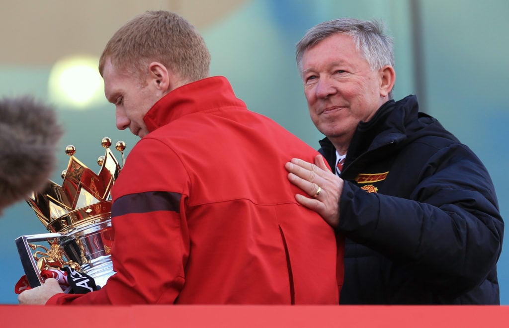 Manchester United manager Sir Alex Ferguson pats Paul Scholes on the back at the start of their Barclays Premier League Trophy Parade through Manch...