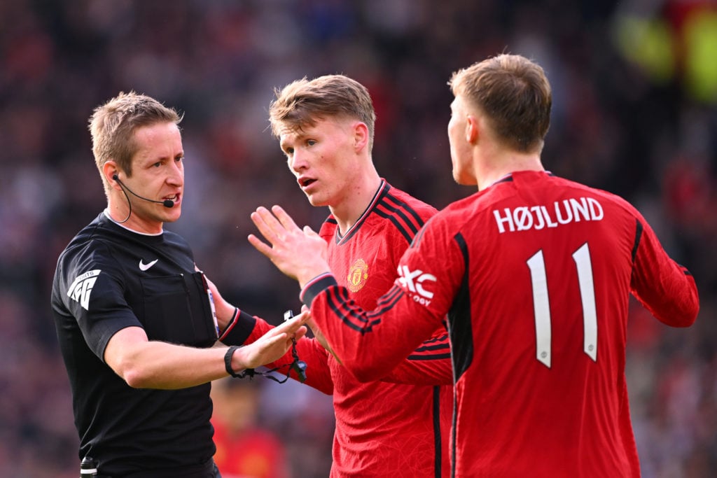 Referee John Brooks gestures as Scott McTominay and Rasmus Hojlund of Manchester United appeal for a penalty during the Emirates FA Cup Quarter Fin...