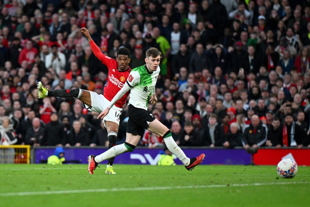 Amad Diallo of Manchester United scores his team's fourth goal whilst under pressure from Conor Bradley of Liverpool during the Emirates FA Cup Qua...