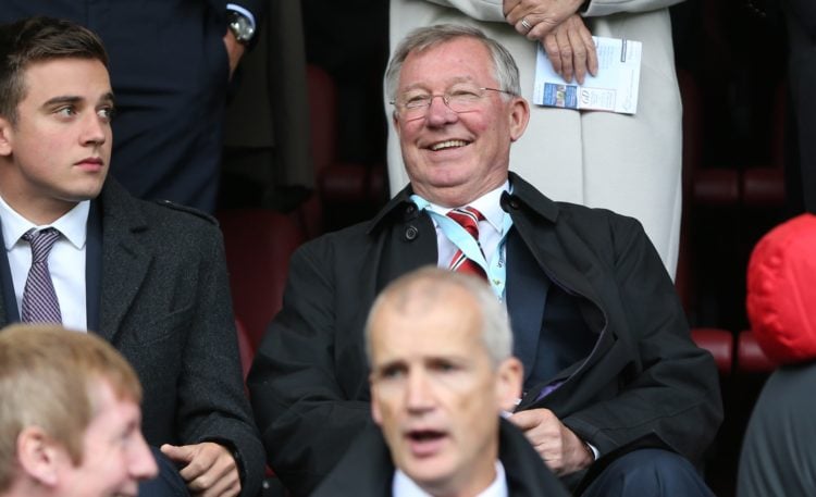 Manchester Uniteds Scottish former manager Alex Ferguson (R) laughs as he sits in the stands to watch the English Premier League football match bet...