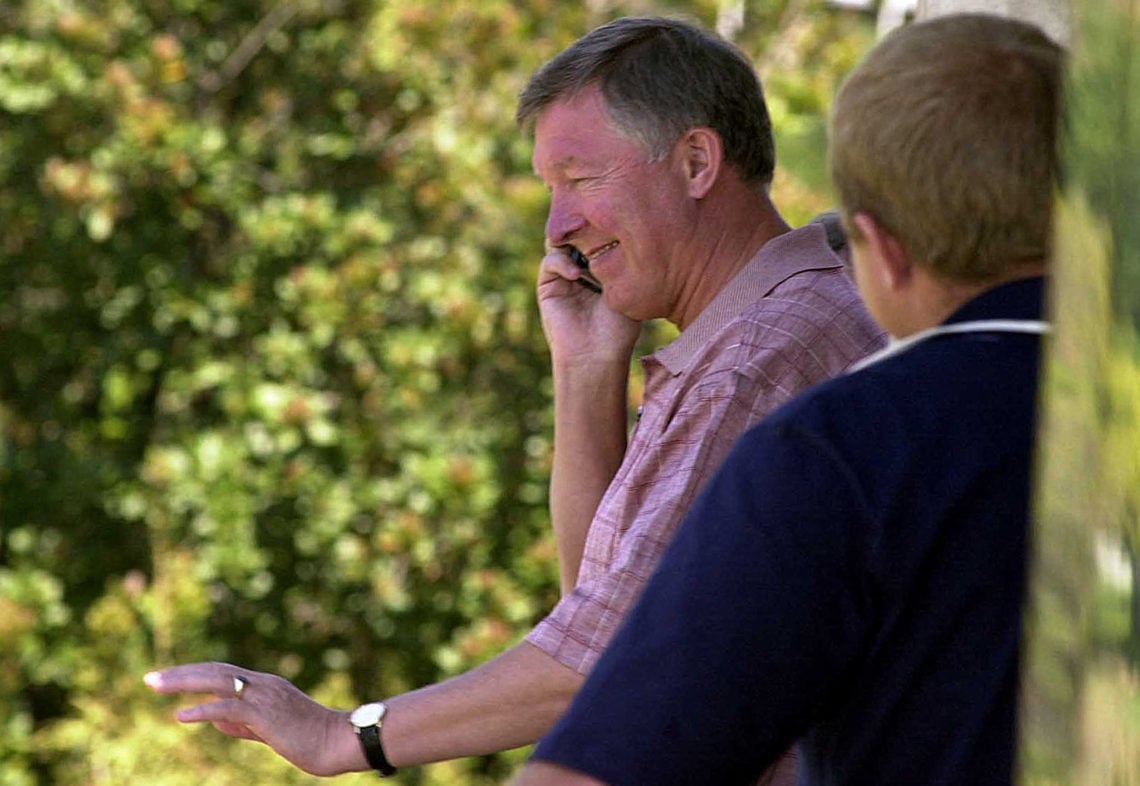 Alex Ferguson Manchester United's manager speaks on his cell phone 12 October 2002 on his way out from a soccer school in Pretoria.  Ferguson has b...
