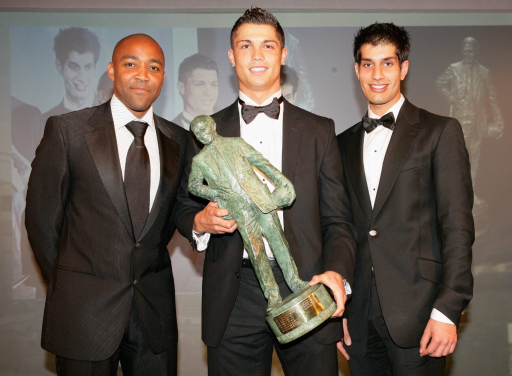 Cristiano Ronaldo (C) of Manchester United is presented with his Sir Matt Busby Player of the Year award by Darren Campbell (L) and an auction winn...