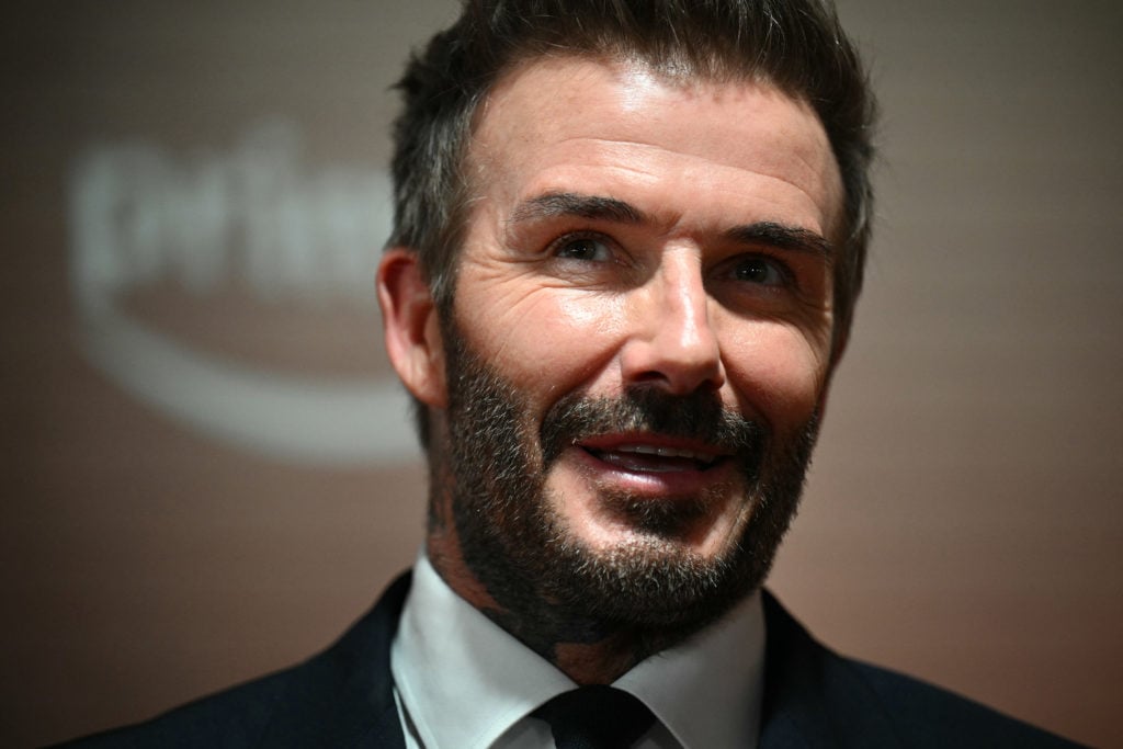 Former Manchester United footballer David Beckham reacts on the red carpet upon arrival to attend the world premiere of the documentary '99', in Ma...