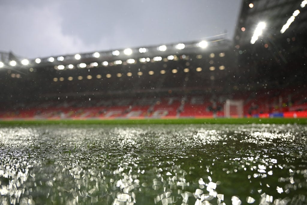 A detailed view of a puddle of water on the surface of the Old Trafford pitch, during a spell of heavy rain, after the Premier League match between...