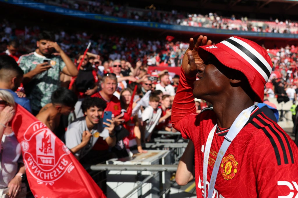 Kobbie Mainoo of Manchester United celebrates with the fans after the Emirates FA Cup Final match between Manchester City and Manchester United at ...