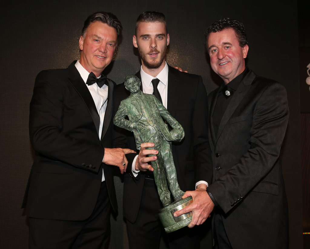 (EXCLUSIVE COVERAGE) David de Gea of Manchester United is presented with the Sir Matt Busby Player of the Year trophy by Manager Louis van Gaal and...