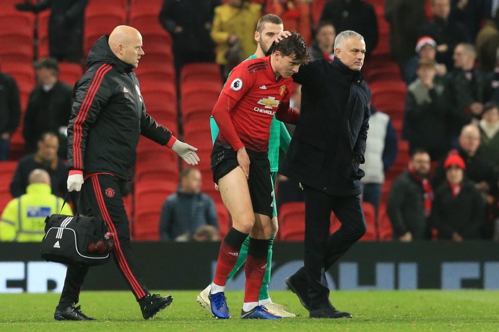 Manchester United's Portuguese manager Jose Mourinho (R) consoles Manchester United's Swedish defender Victor Lindelof (C) during the English Premi...