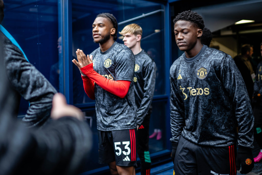 Willy Kambwala and Kobbie Mainoo of Manchester United warm up ahead of the Premier League match between Manchester City and Manchester United at Et...