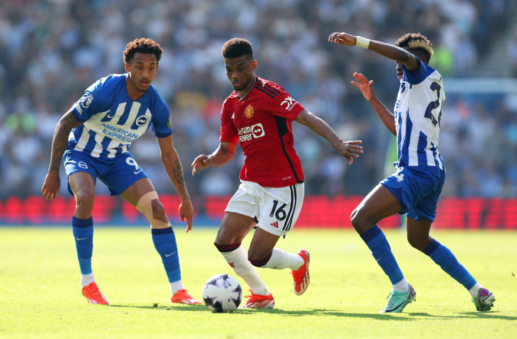 Amad Diallo of Manchester United battles for possession with Joao Pedro and Simon Adingra of Brighton & Hove Albion during the Premier League match...