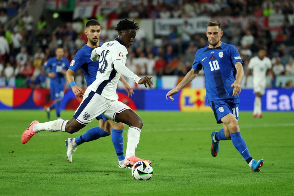 Kobbie Mainoo of England runs with the ball under pressure from Timi Max Elsnik of Slovenia during the UEFA EURO 2024 group stage match between Eng...