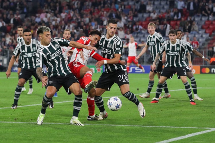 Jamal Musiala of Bayern Munich battles for possession with Lisandro Martinez and Diogo Dalot of Manchester United during the UEFA Champions League ...