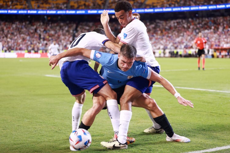 Manuel Ugarte #5 of Uruguay battles for the ball with Christian Pulisic #10 and Tyler Adams #4 of the United States during the second half at GEHA ...