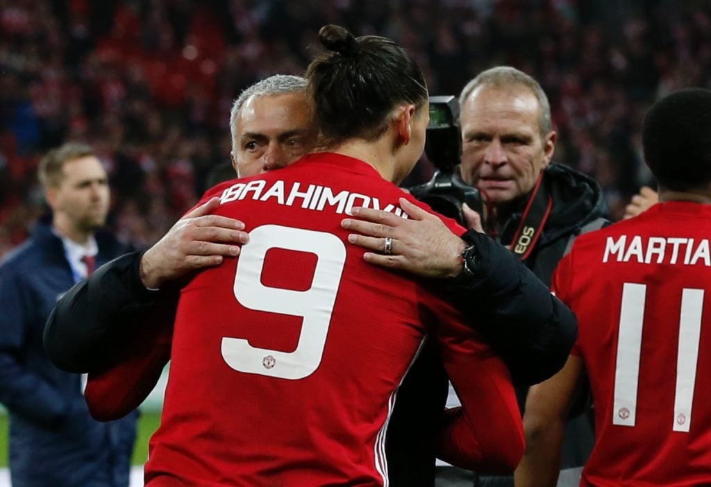 Manchester United's Swedish striker Zlatan Ibrahimovic embraces Manchester United's Portuguese manager Jose Mourinho as players celebrate on the pi...