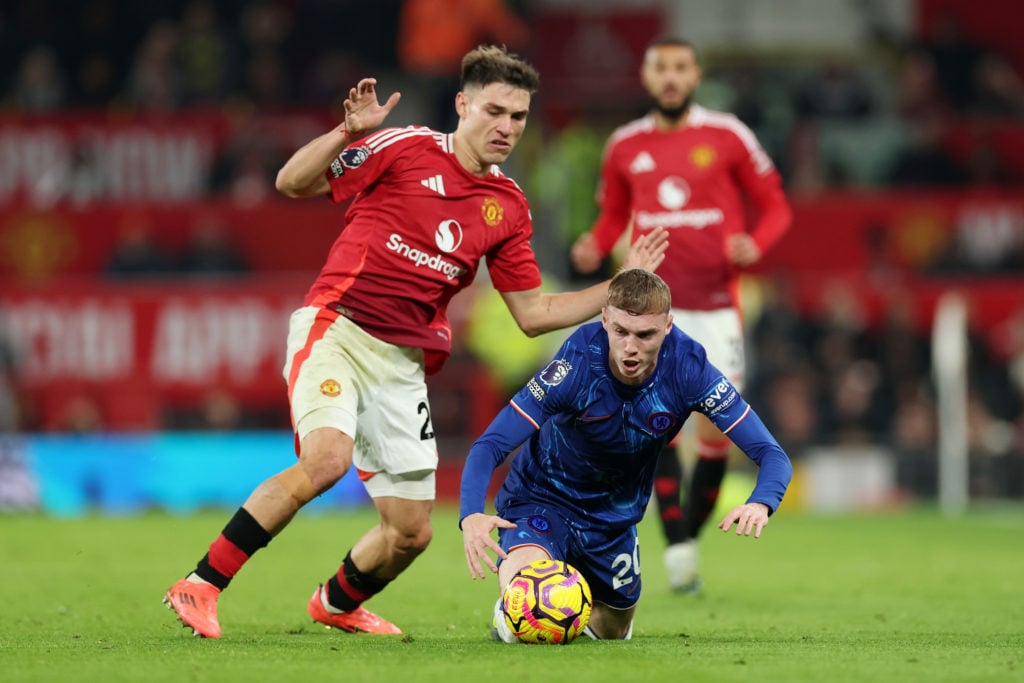 Cole Palmer of Chelsea falls while fighting for possession with Manuel Ugarte of Manchester United during the Premier League match between Manchester...