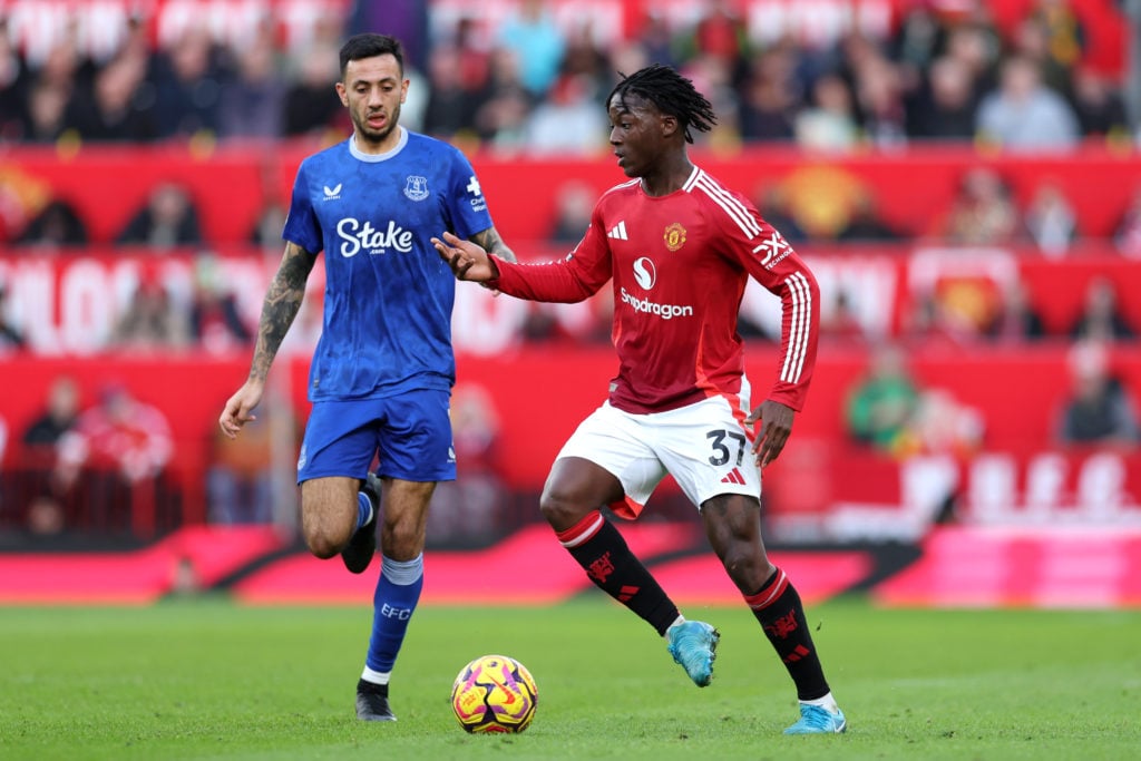 Kobbie Mainoo of Manchester United runs with the ball whilst under pressure from Dwight McNeil of Everton during the Premier League match between M...