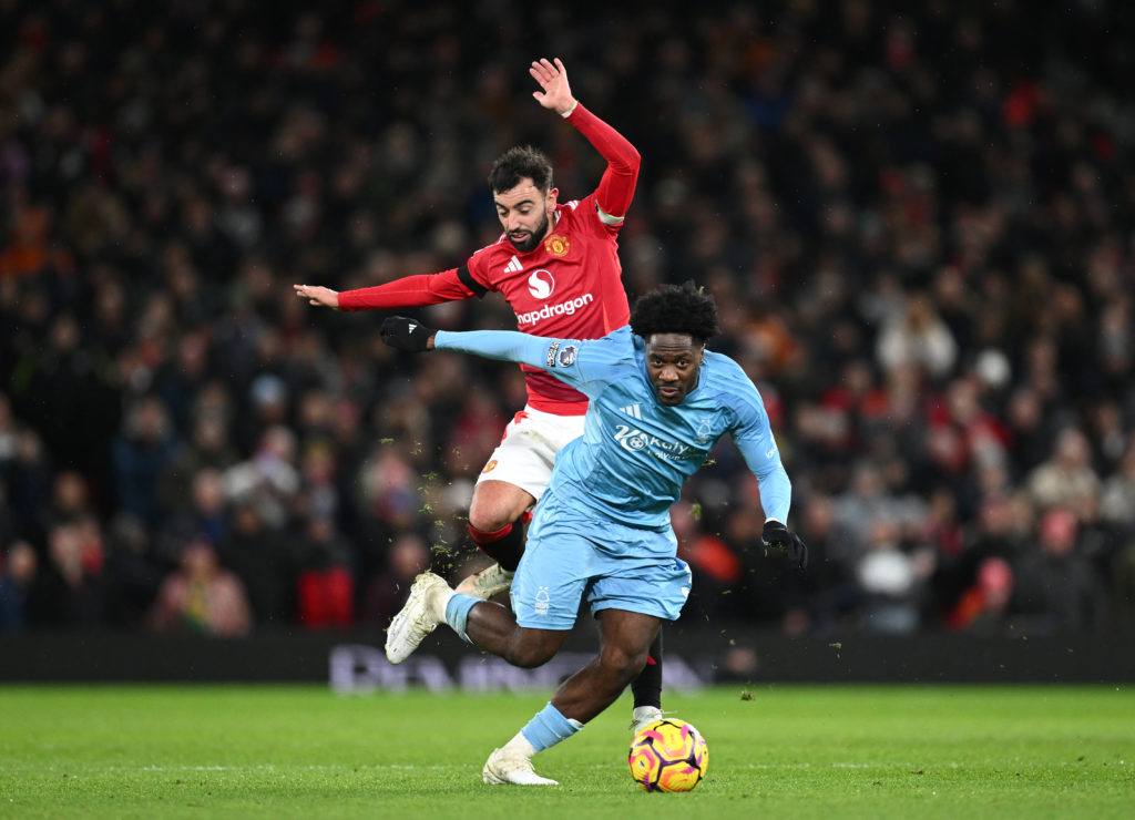 Ola Aina of Nottingham Forest is challenged by Bruno Fernandes of Manchester United during the Premier League match between Manchester United FC an...