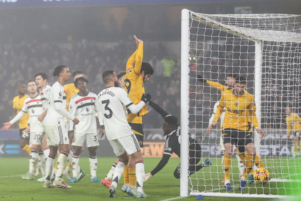 Matheus Cunha of Wolves, wearing #10, beats goalkeeper Andre Onana of Manchester United, wearing #24, to score during the Premier League match betw...