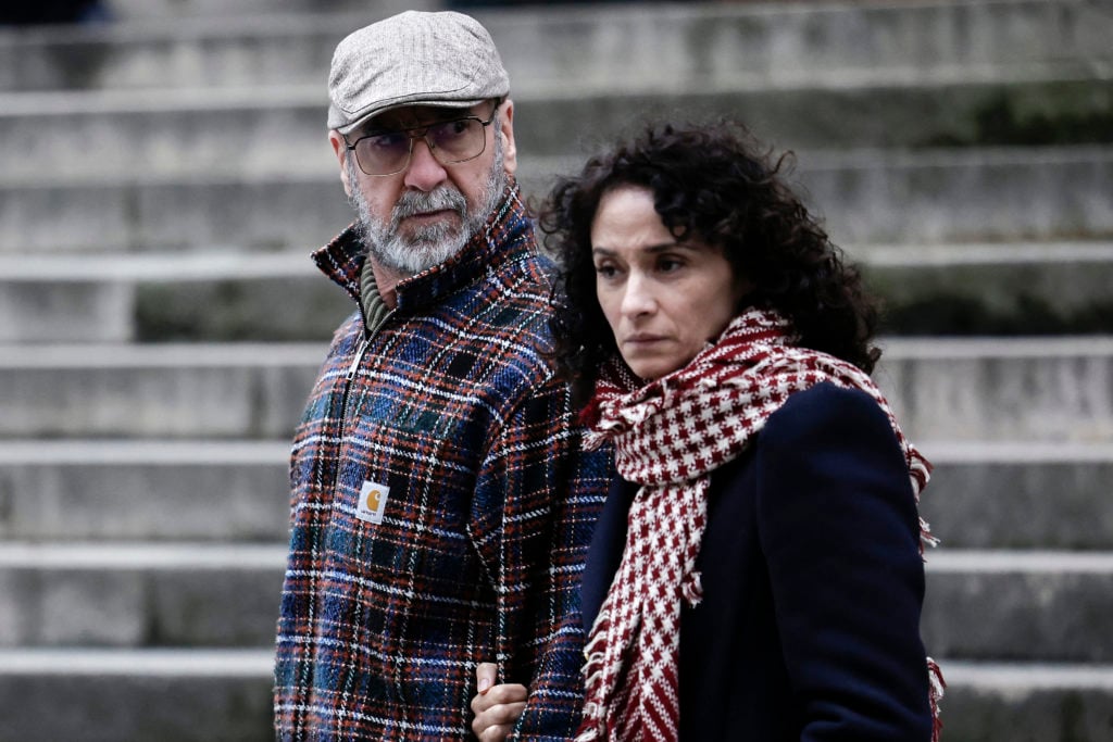 French former football player and actor Eric Cantona (L) and his wife French actress Rachida Brakni leave after they attended the funeral ceremony ...