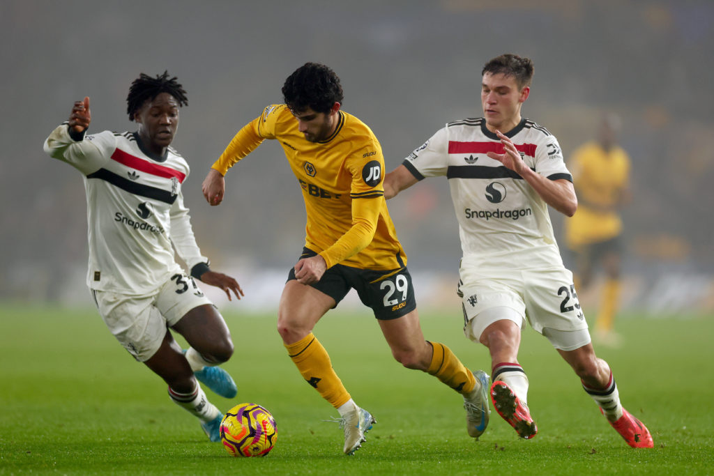 Goncalo Guedes of Wolverhampton Wanderers tackles Manuel Ugarte and Kobbie Mainoo of Manchester Utd during the Premier League match between Wolverhampton...