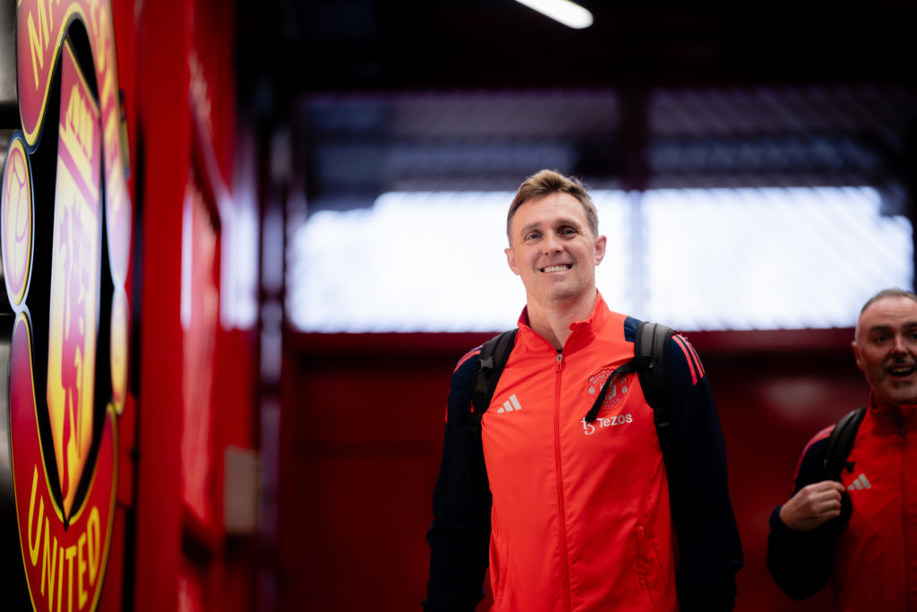 Darren Fletcher enters Old Trafford next to Manchester United badge.