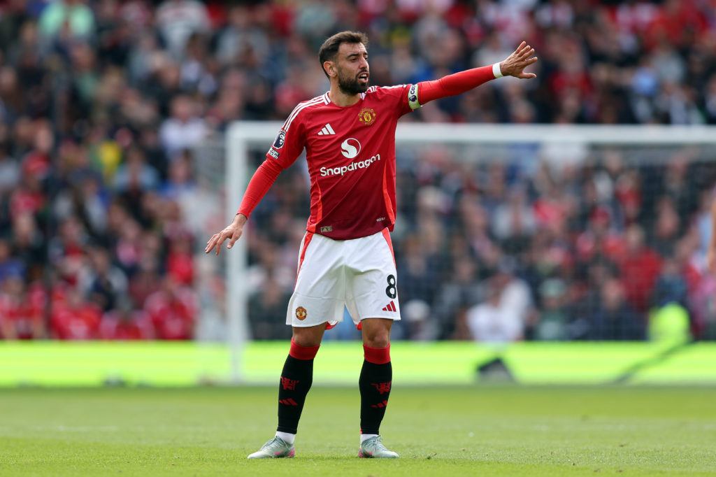 Bruno Fernandes points at teammates during Manchester United game.