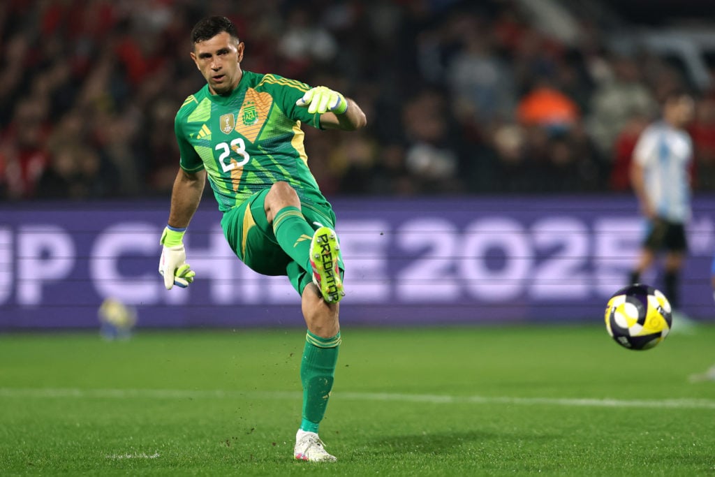 Emiliano Martinez plays a pass while in green Argentina goalkeeper kit.