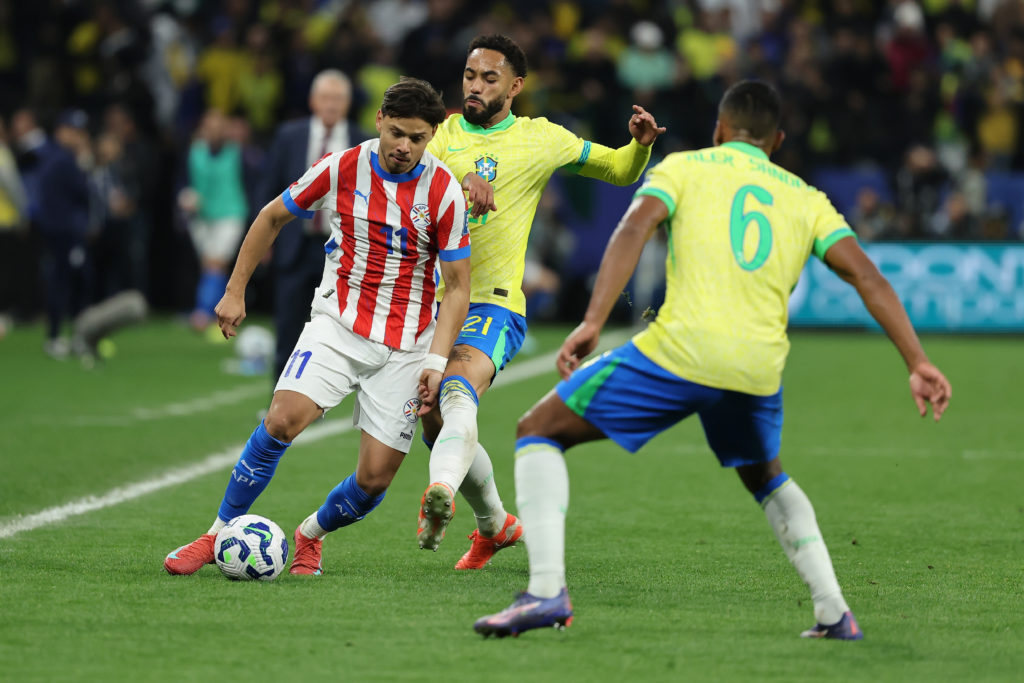 Angel Romero of Paraguay is put under pressure by Matheus Cunha of Brazil during the FIFA World Cup 2026 South American Qualifier between Brazil and Paraguay