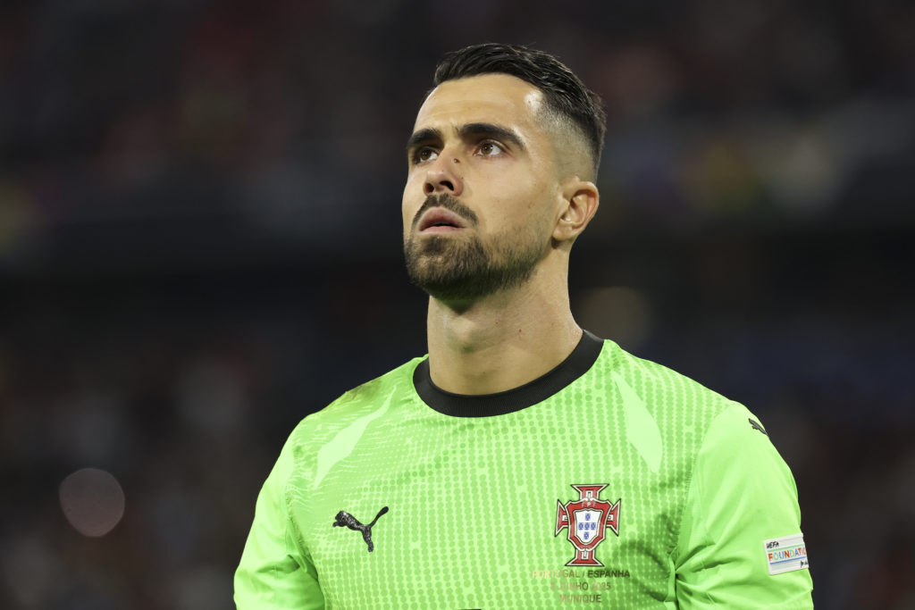 Diogo Costa staring toward the sky while wearing green Portugal goalkeeper kit.