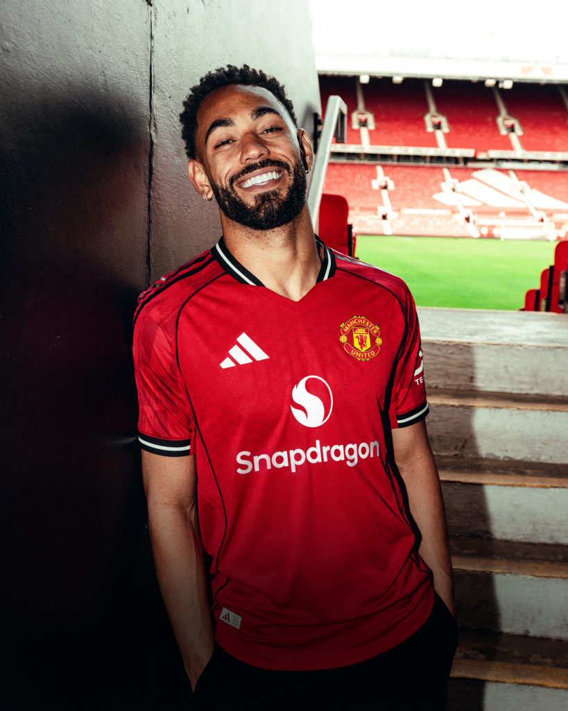 Matheus Cunha posing in a Manchester United shirt