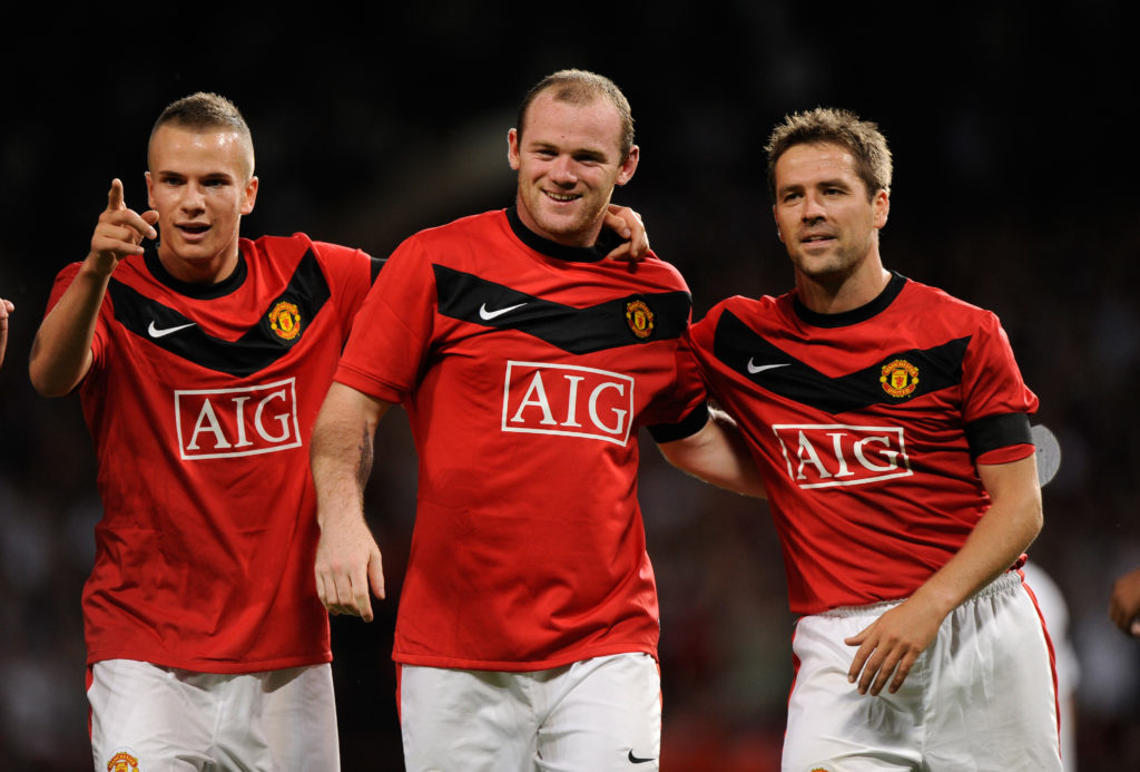 Wayne Rooney of Manchester United celebrates with Tom Cleverley and Michael Owen after scoring against Valencia.